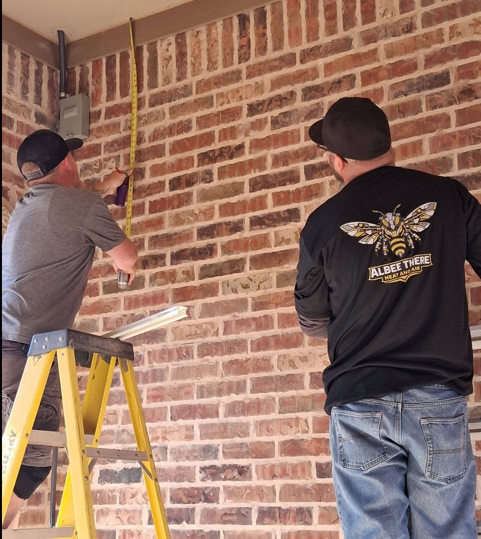 HVAC technicians measuring and preparing for installation